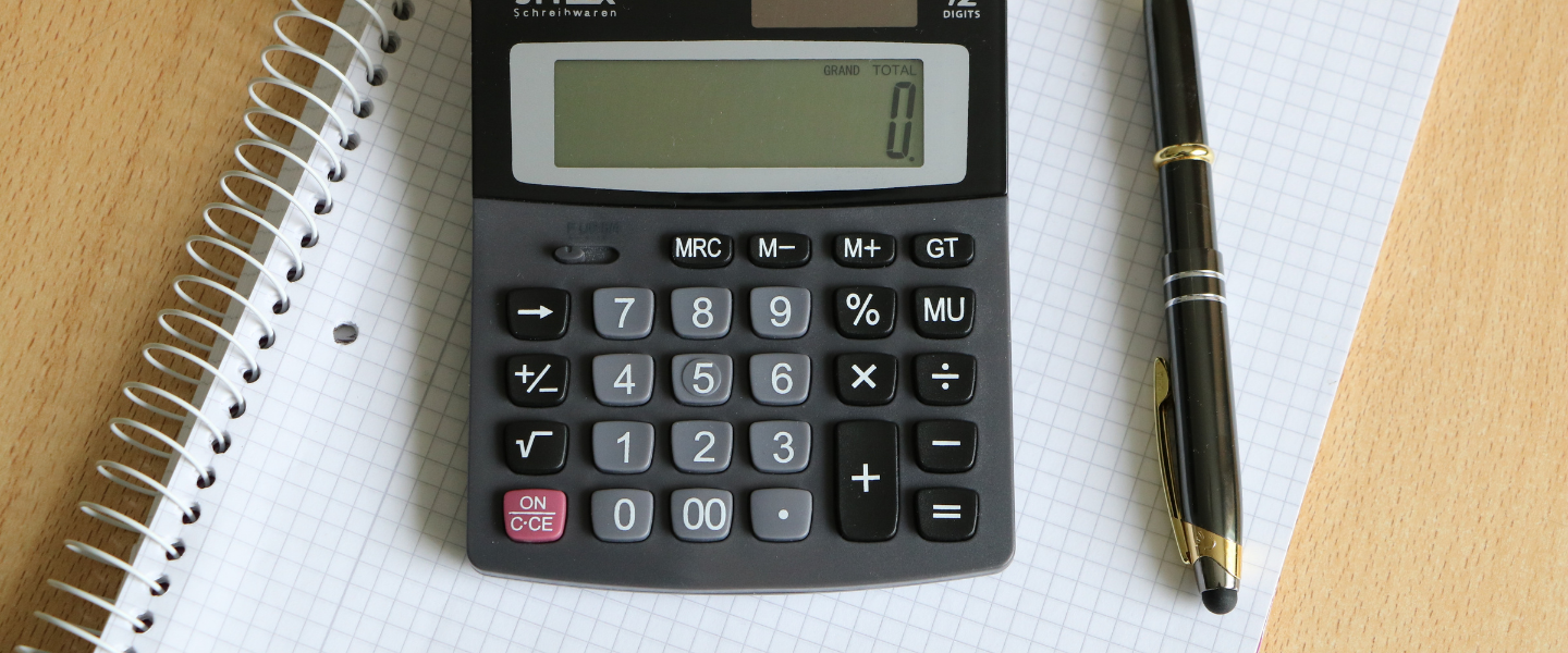 Calculator, pen, and graph paper on desk